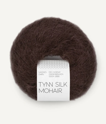 A ball of Tynn Silk Mohair yarn in a brown-red color with a 'Tynn Silk Mohair' label from Sandnes Garn