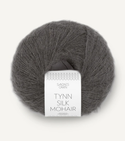 A ball of Tynn Silk Mohair yarn in a green-grey color with a 'Tynn Silk Mohair' label from Sandnes Garn