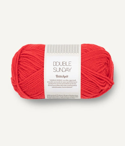 A ball of poppy coloured merino wool yarn labeled 'Double Sunday' by Sandnesgarn.