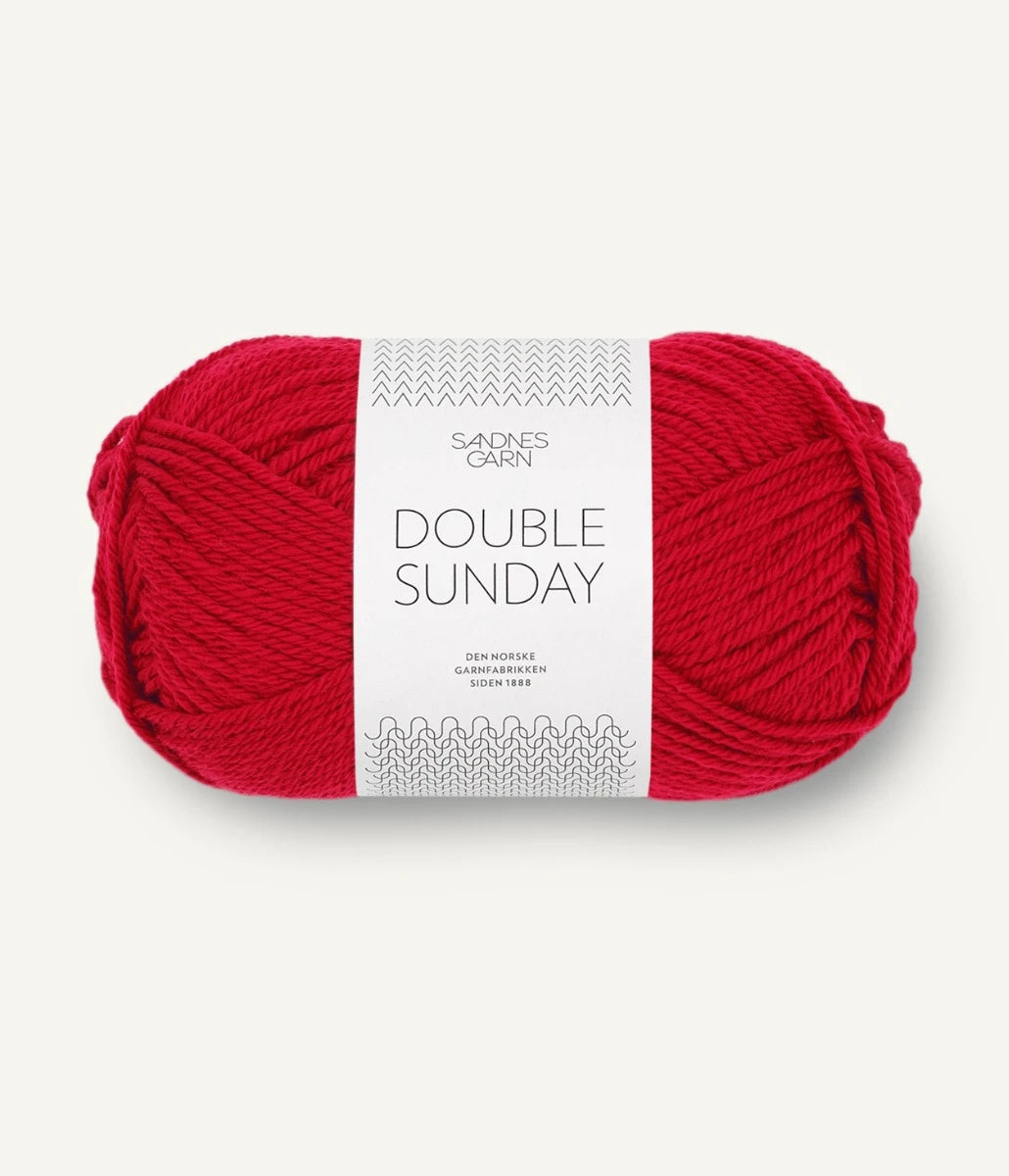 A ball of red coloured merino wool yarn labeled 'Double Sunday' by Sandnesgarn.