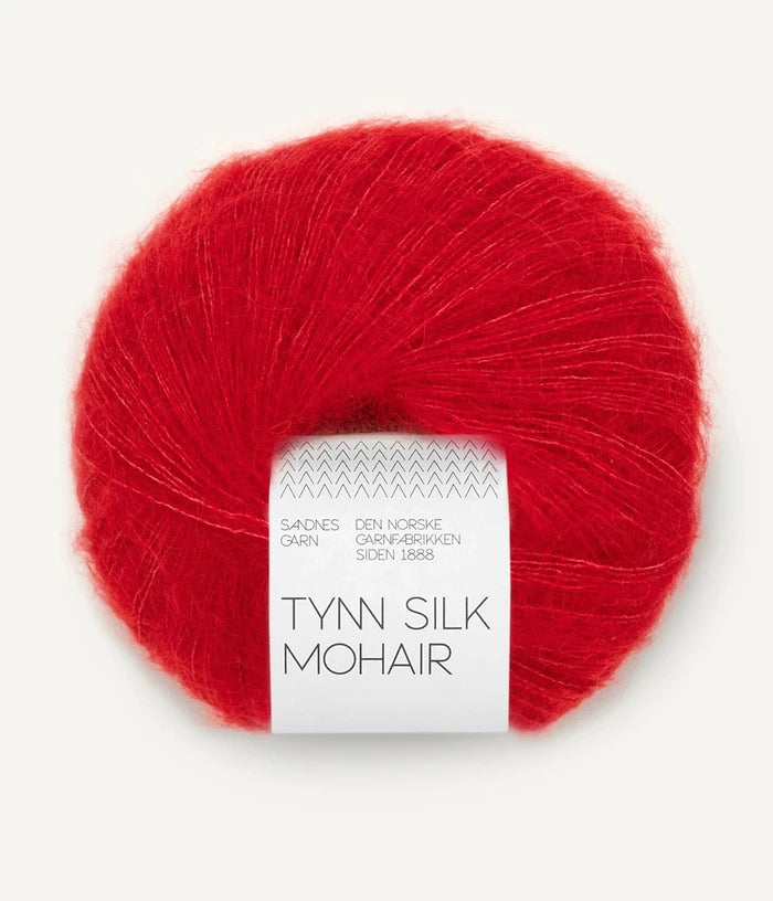 A ball of Tynn Silk Mohair yarn in a bright red color with a 'Tynn Silk Mohair' label from Sandnes Garn