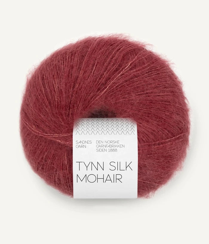 A ball of Tynn Silk Mohair yarn in a dusty rose color with a 'Tynn Silk Mohair' label from Sandnes Garn