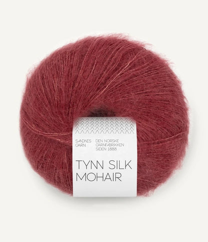 A ball of Tynn Silk Mohair yarn in a dusty rose color with a 'Tynn Silk Mohair' label from Sandnes Garn