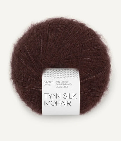 A ball of Tynn Silk Mohair yarn in a brown-red color with a 'Tynn Silk Mohair' label from Sandnes Garn