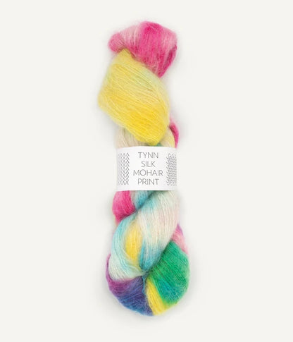 A skein of Tynn Silk Mohair print yarn in a blend of yellow, pink, teal, prurple, green, and white colors.