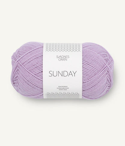 A ball of Sandnesgarn Sunday merino wool yarn in a lilac color, with packaging that includes the brand and product name.