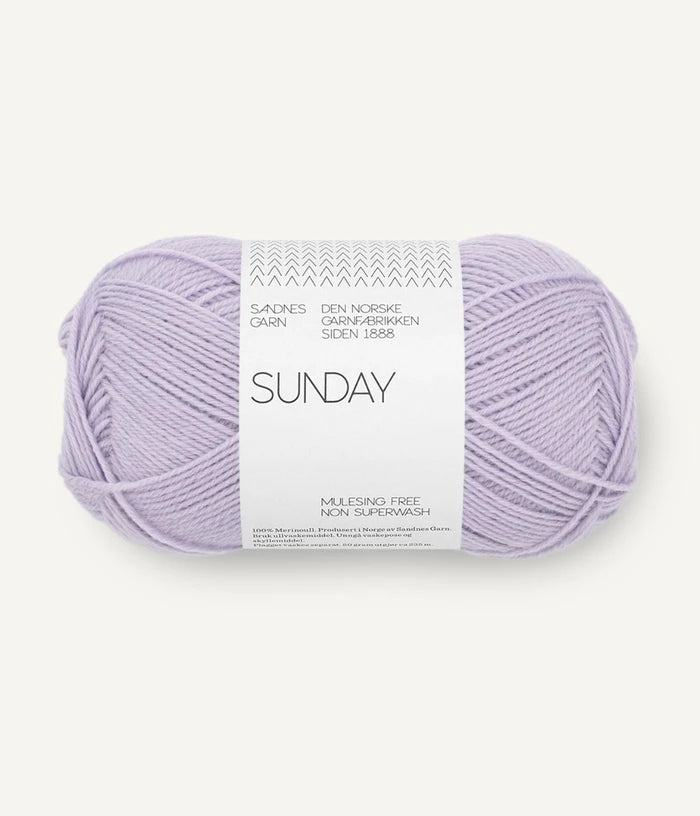 A ball of Sandnesgarn Sunday merino wool yarn in a lavender color, with packaging that includes the brand and product name.