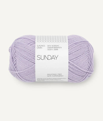 A ball of Sandnesgarn Sunday merino wool yarn in a lavender color, with packaging that includes the brand and product name.