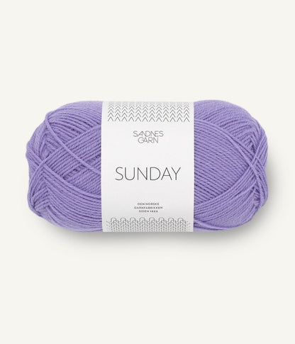 A ball of Sandnesgarn Sunday merino wool yarn in a purple color, with packaging that includes the brand and product name.