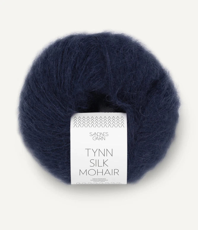 A ball of Tynn Silk Mohair yarn in a dark navy color with a 'Tynn Silk Mohair' label from Sandnes Garn