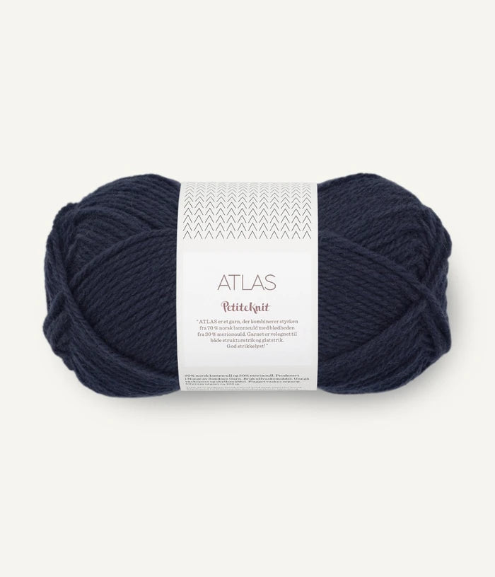 Navy blue ball of yarn with a label on a white background
