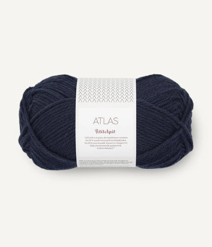 Navy blue ball of yarn with a label on a white background