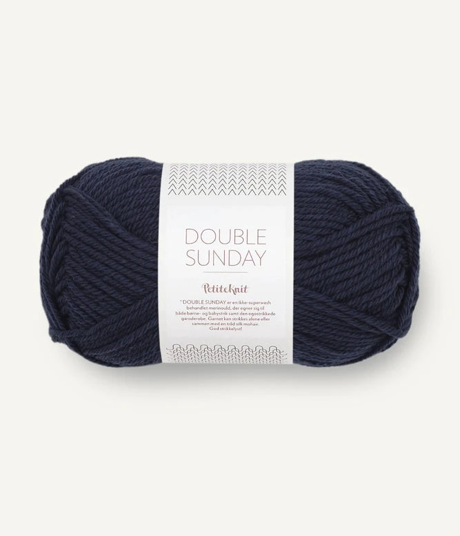 A ball of navy blue coloured merino wool yarn labeled 'Double Sunday' by Sandnesgarn.