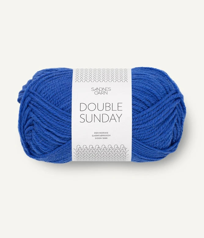 A ball of cobalt blue coloured merino wool yarn labeled 'Double Sunday' by Sandnesgarn.