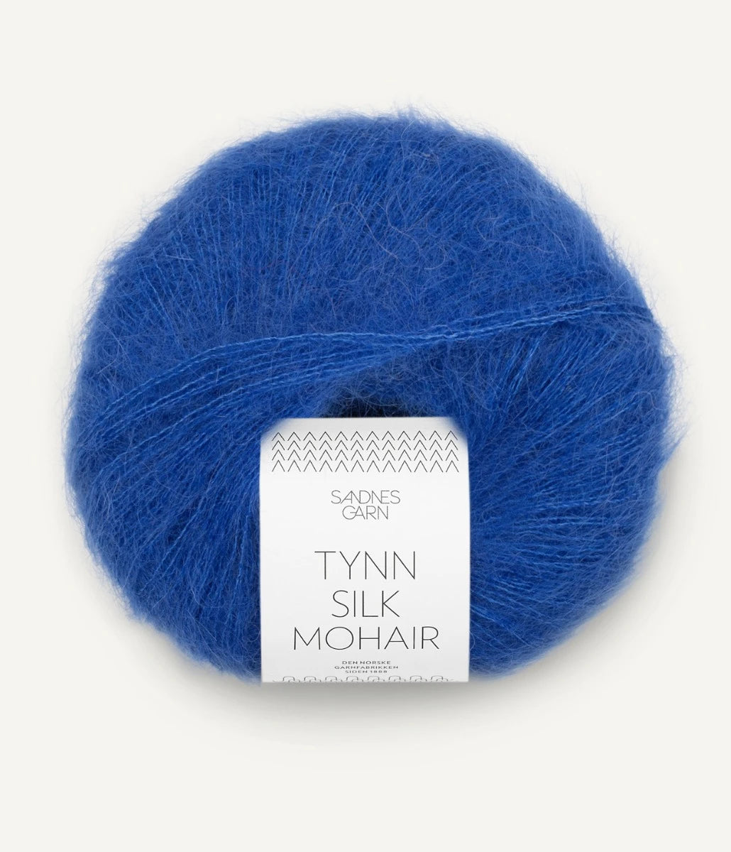 A ball of Tynn Silk Mohair yarn in a cobalt blue color with a 'Tynn Silk Mohair' label from Sandnes Garn