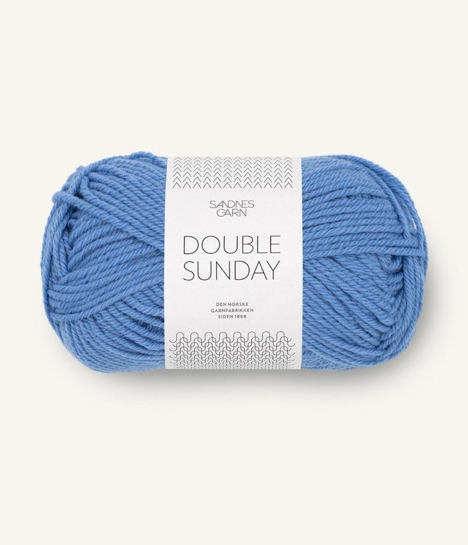 A ball of blue coloured merino wool yarn labeled 'Double Sunday' by Sandnesgarn.