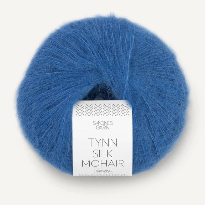 A ball of Tynn Silk Mohair yarn in a blue color with a 'Tynn Silk Mohair' label from Sandnes Garn