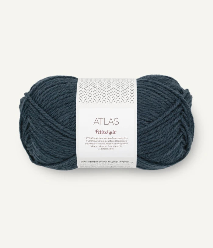 Ball of dusty blue yarn with a label on a white background