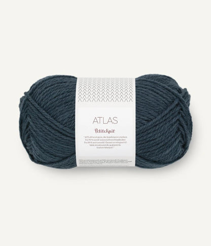 Ball of dusty blue yarn with a label on a white background