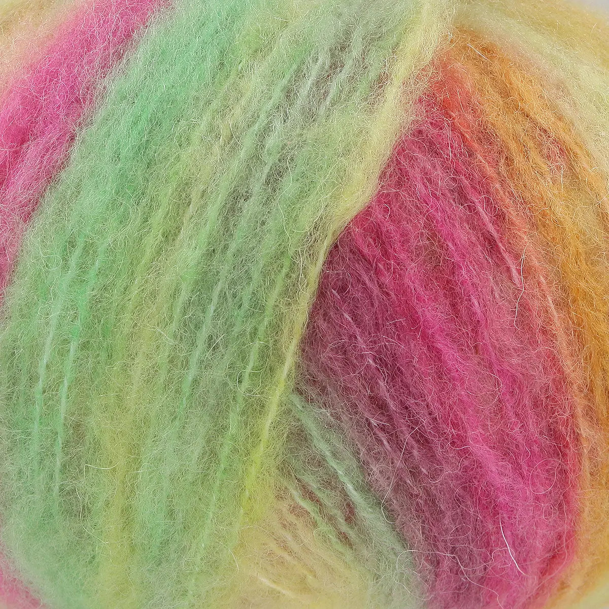 A close-up of acrylic, mohair, polyester, and wool yarn in pink, green, and yellow hues