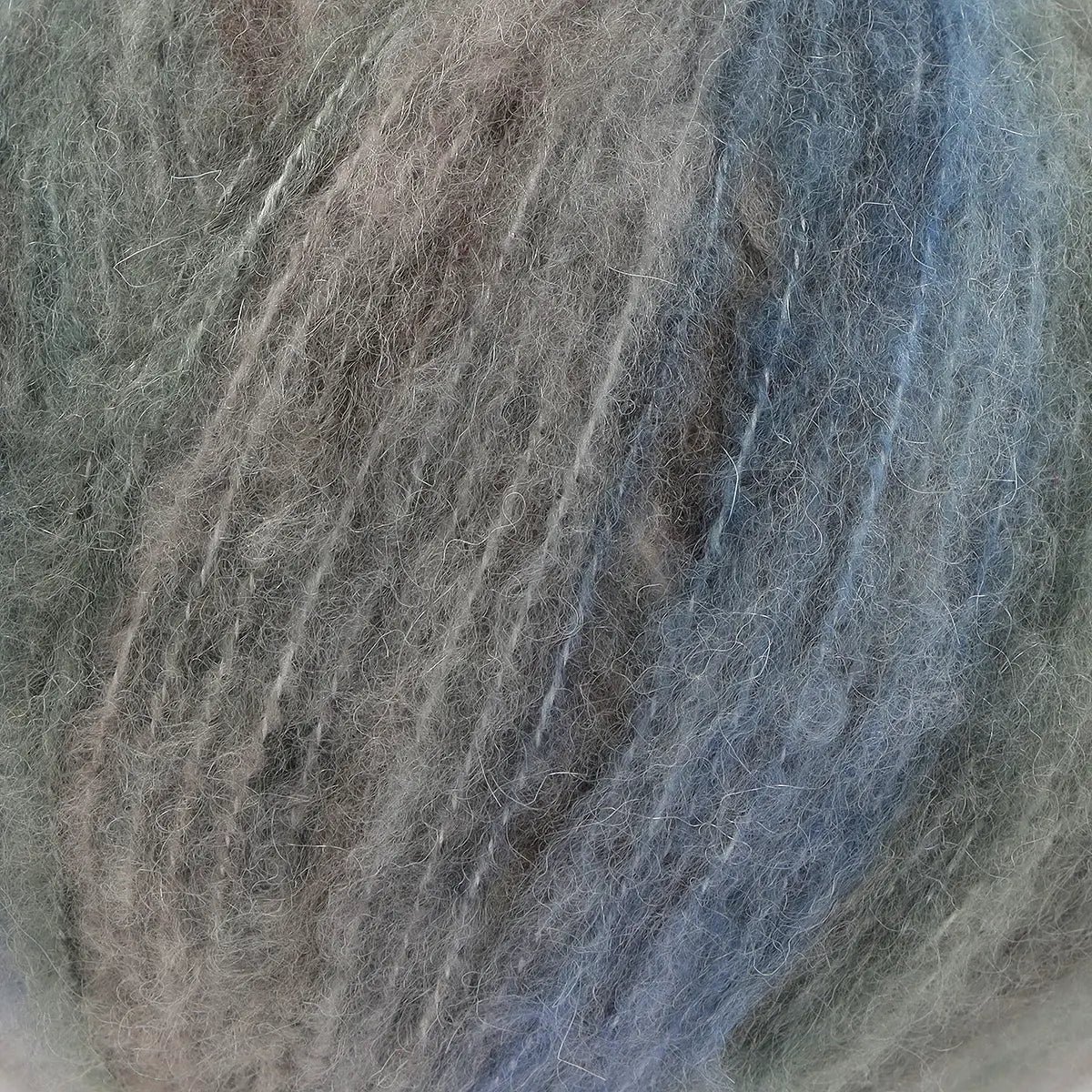 A close-up of acrylic, mohair, polyester, and wool yarn in gray, blue, and brown colors