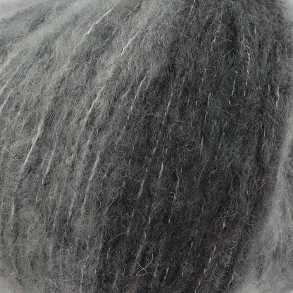 A close-up of acrylic, mohair, polyester, and wool yarn in grey tones