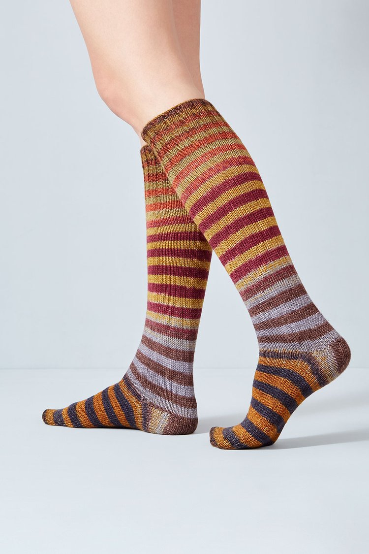 Merino and nylon knit red, brown, yellow, and indigo stripe socks from Urth