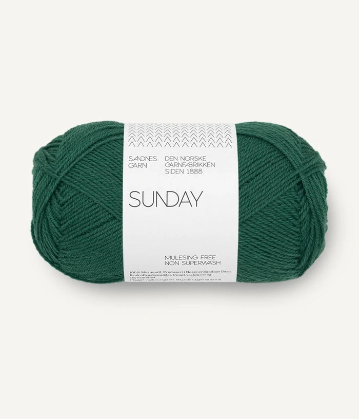 A ball of Sandnesgarn Sunday merino wool yarn in a green color, with packaging that includes the brand and product name.