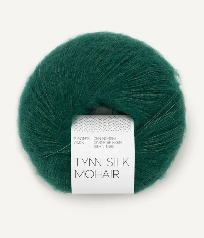A ball of Tynn Silk Mohair yarn in a  deep green color with a 'Tynn Silk Mohair' label from Sandnes Garn