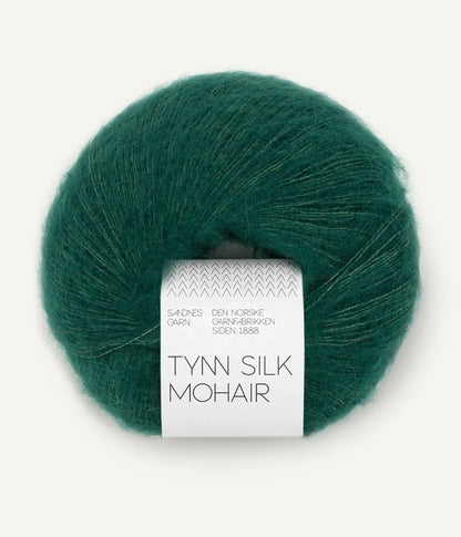 A ball of Tynn Silk Mohair yarn in a  deep green color with a 'Tynn Silk Mohair' label from Sandnes Garn