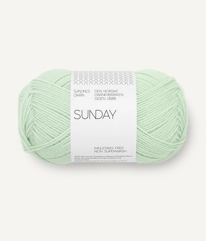 A ball of Sandnesgarn Sunday merino wool yarn in a mint color, with packaging that includes the brand and product name.