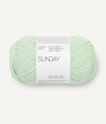 A ball of Sandnesgarn Sunday merino wool yarn in a mint color, with packaging that includes the brand and product name.
