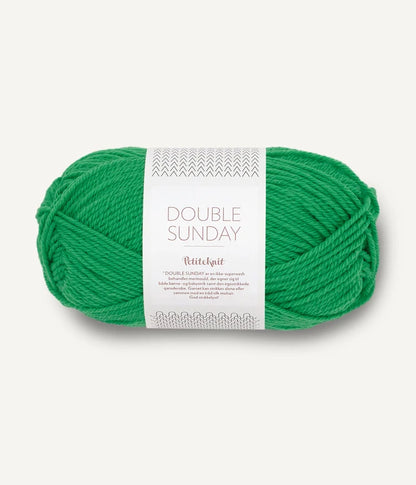 A ball of kelly green coloured merino wool yarn labeled 'Double Sunday' by Sandnesgarn.