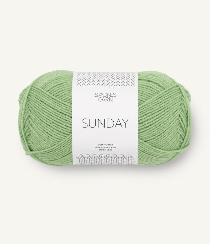 A ball of Sandnesgarn Sunday merino wool yarn in a green color, with packaging that includes the brand and product name.