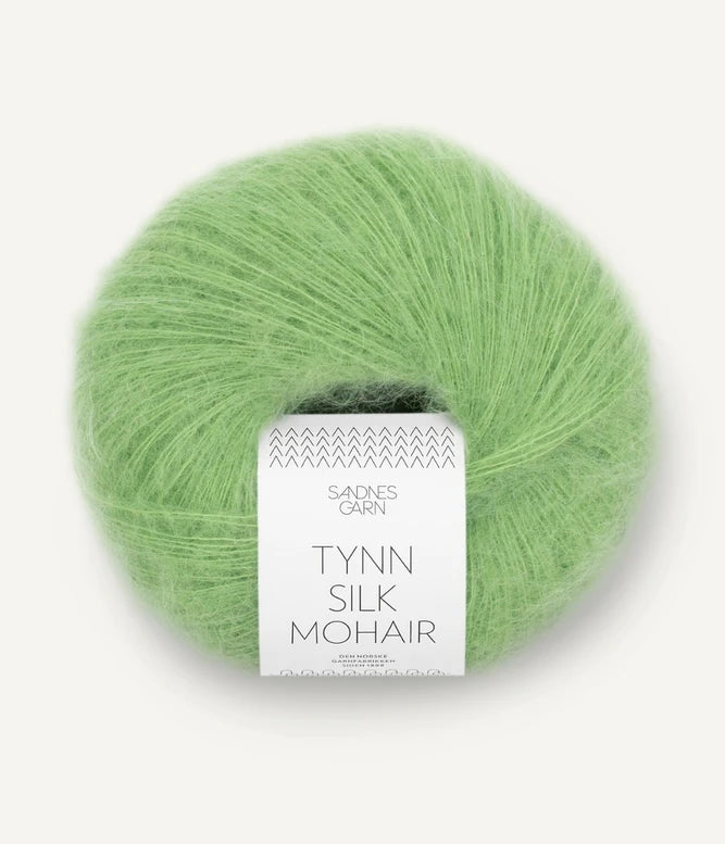 A ball of Tynn Silk Mohair yarn in a bright green color with a 'Tynn Silk Mohair' label from Sandnes Garn