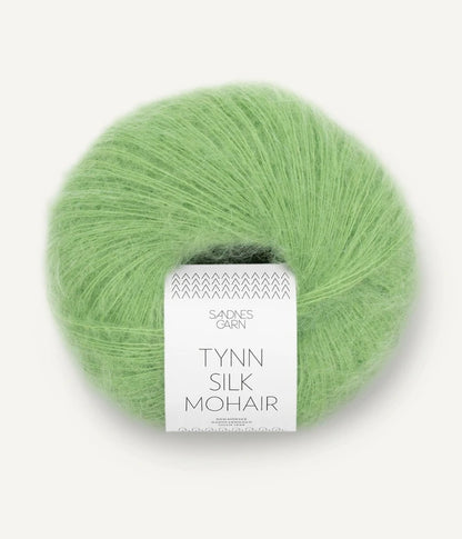 A ball of Tynn Silk Mohair yarn in a bright green color with a 'Tynn Silk Mohair' label from Sandnes Garn