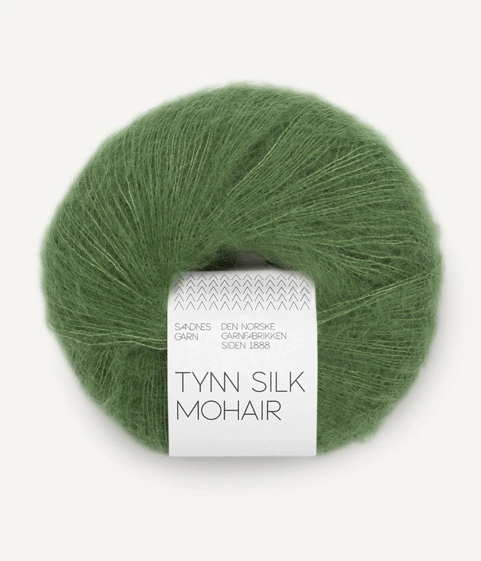 A ball of Tynn Silk Mohair yarn in a soft green color with a 'Tynn Silk Mohair' label from Sandnes Garn