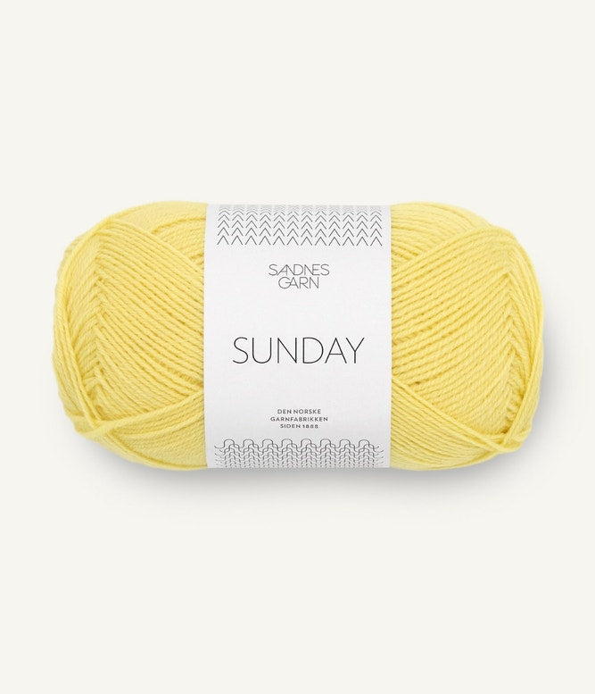 A ball of Sandnesgarn Sunday merino wool yarn in a lemon color, with packaging that includes the brand and product name.