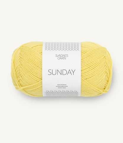 A ball of Sandnesgarn Sunday merino wool yarn in a lemon color, with packaging that includes the brand and product name.
