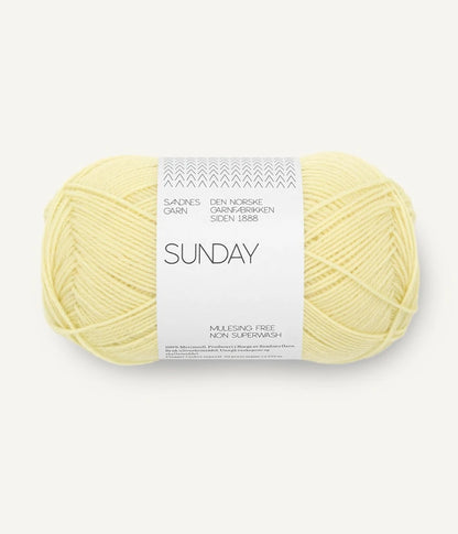A ball of Sandnesgarn Sunday merino wool yarn in a yellow color, with packaging that includes the brand and product name.