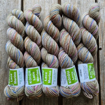 Four skeins of variegated colored merino lace weight yarn labeled 'Koigu Lace Merino'. 