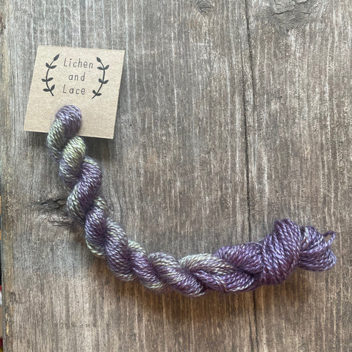 A skein of Baby Eggplant purple embroidery yarn labelled 'Lichen and Lace'.