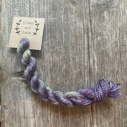 A skein of Baby Eggplant purple embroidery yarn labelled 'Lichen and Lace'.