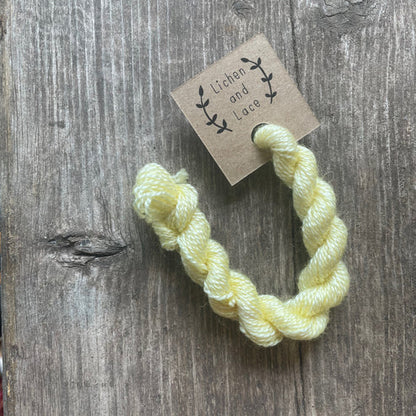 A skein of Buttercup yellow embroidery yarn labelled 'Lichen and Lace'.