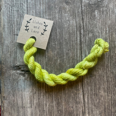 A skein of Citron yellow embroidery yarn labelled 'Lichen and Lace'.