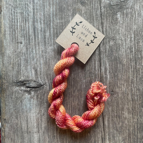 A skein of Day Lily pink embroidery yarn labelled 'Lichen and Lace'.
