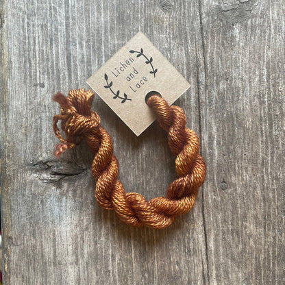 A skein of Ginger Snap brown embroidery yarn labelled 'Lichen and Lace'.