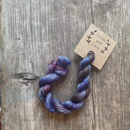 A skein of Huckleberry blue embroidery yarn labelled 'Lichen and Lace'.