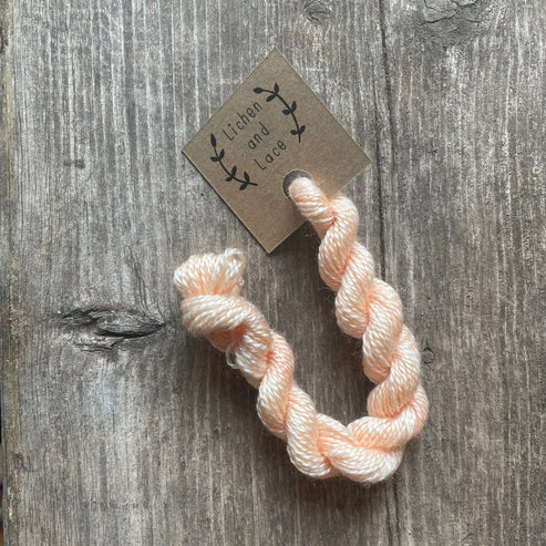 A skein of Peach pink embroidery yarn labelled 'Lichen and Lace'.