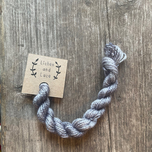 A skein of Pewter grey embroidery yarn labelled 'Lichen and Lace'.